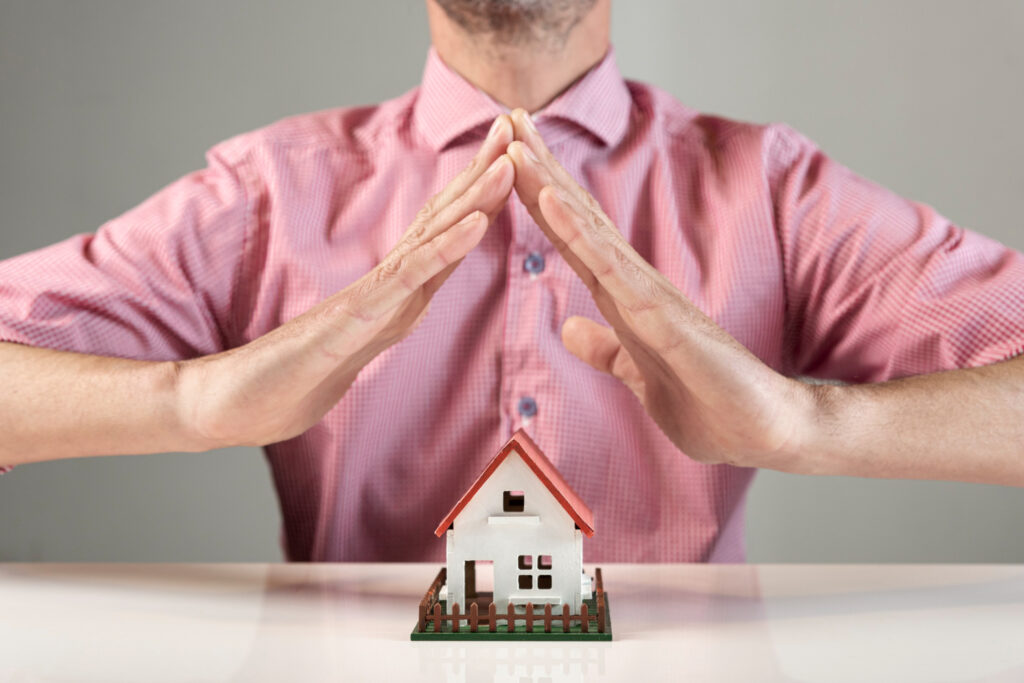 Person creating a roof for house with his hands