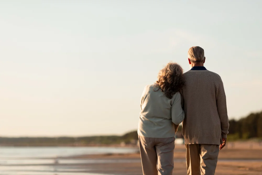 Elderly couple standing together on the seaside, symbolizing lasting love and important end-of-life conversations for the topic 4 Things Your Spouse Should Know Before You Die