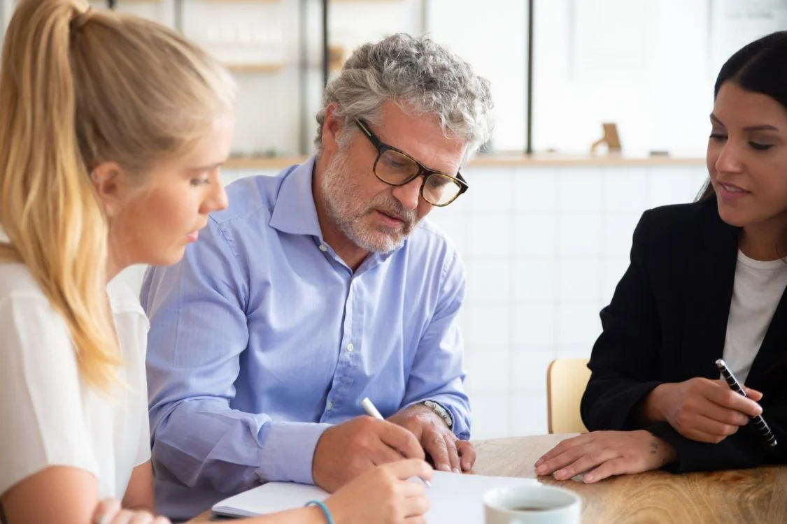 Focused individuals meeting with an agent to finalize paperwork, connecting to the topic, have you chosen the right trustee
